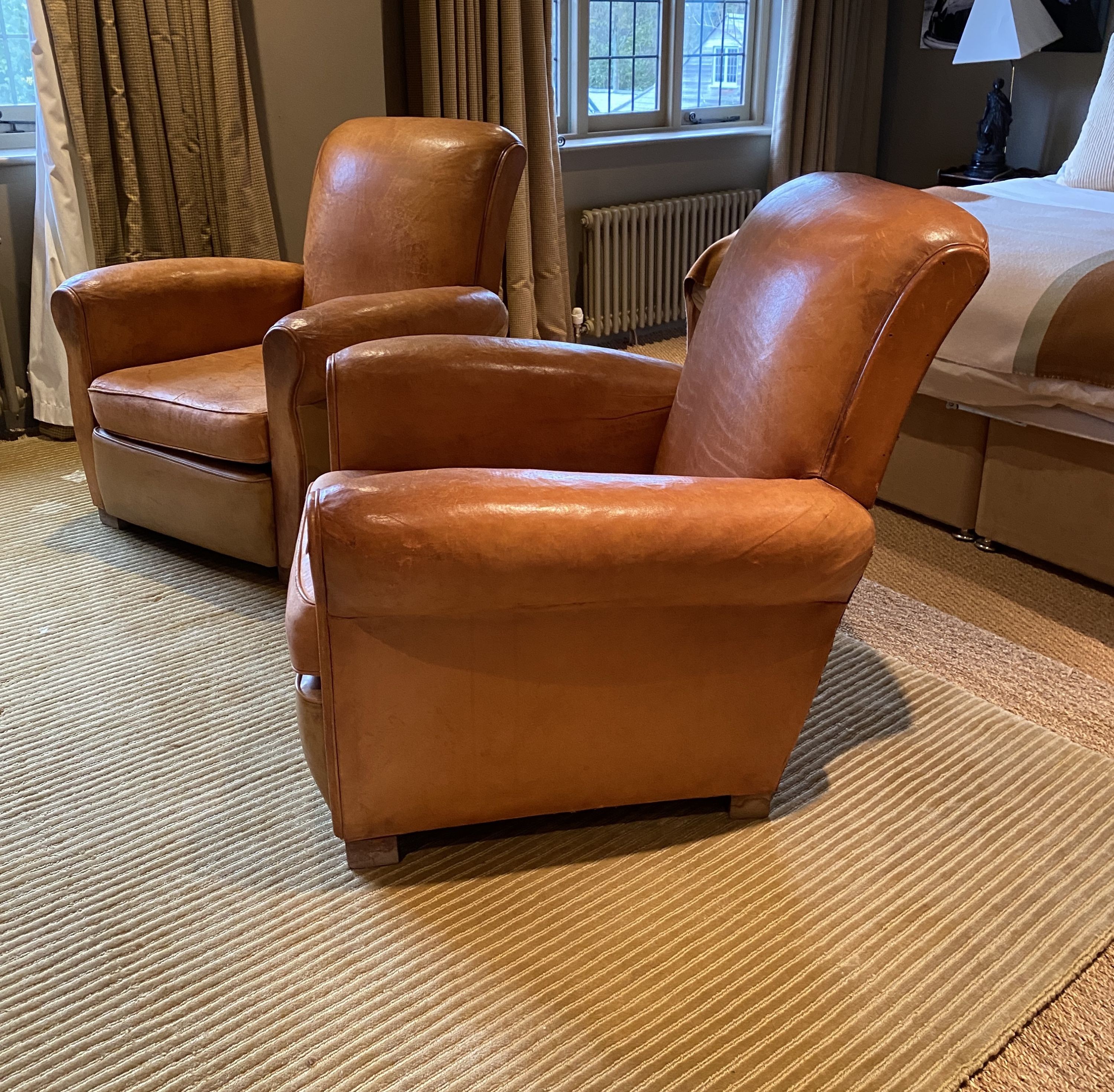 A pair of 1940's French tan leather upholstered armchairs, width 82cm depth 92cm height 84cm